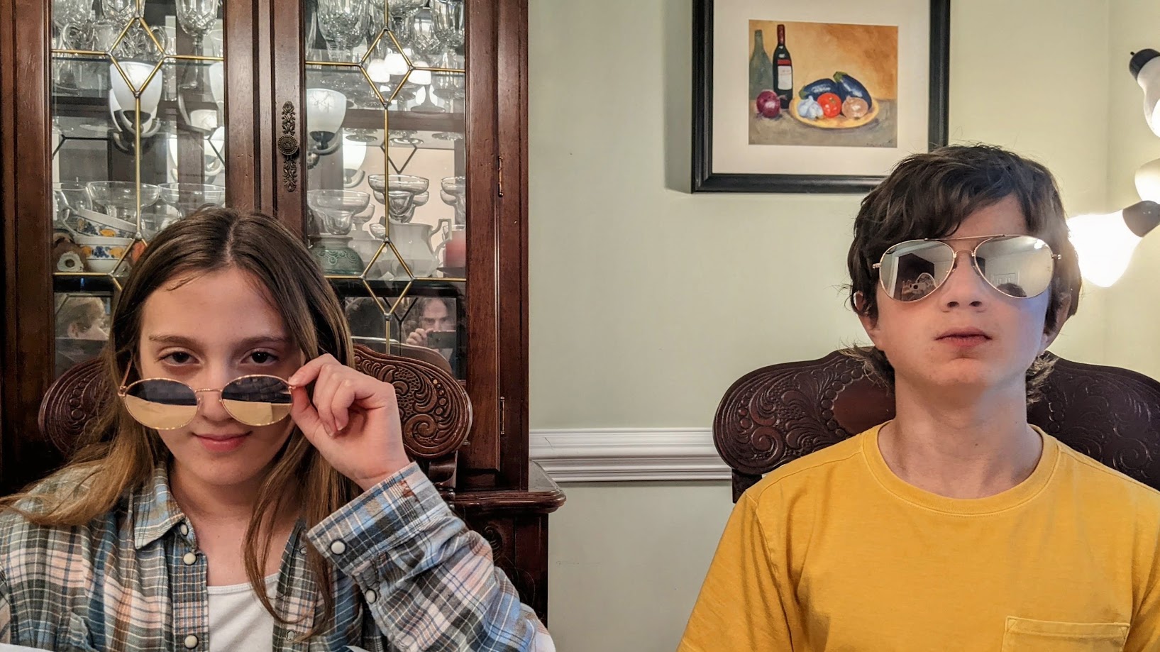 Finn and Fiona at the dining room table in mirrored sunglasses, doing their best too-cool-for-this faces.